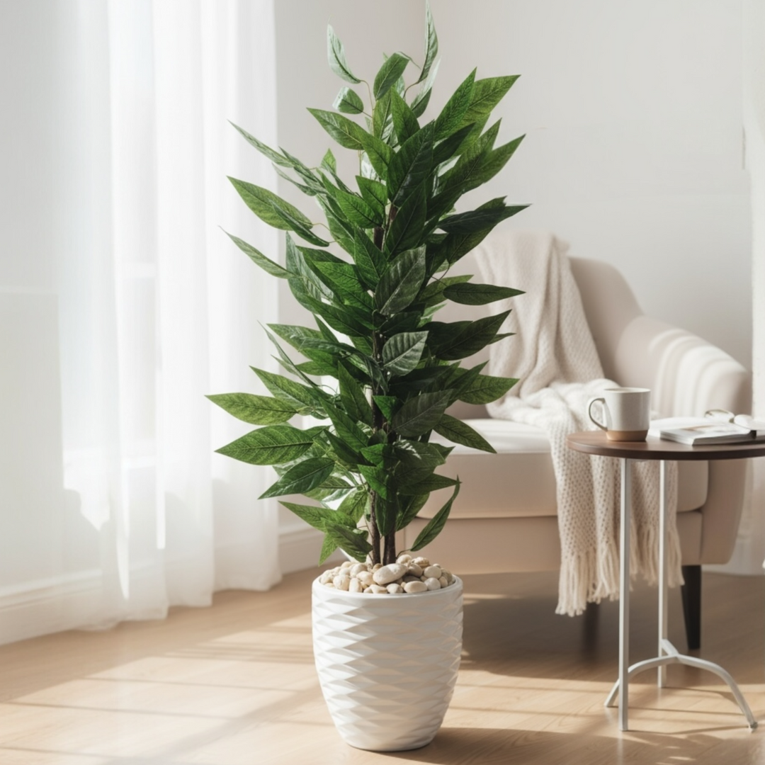 Tall artificial green ficus plant in a white textured pot beside an armchair