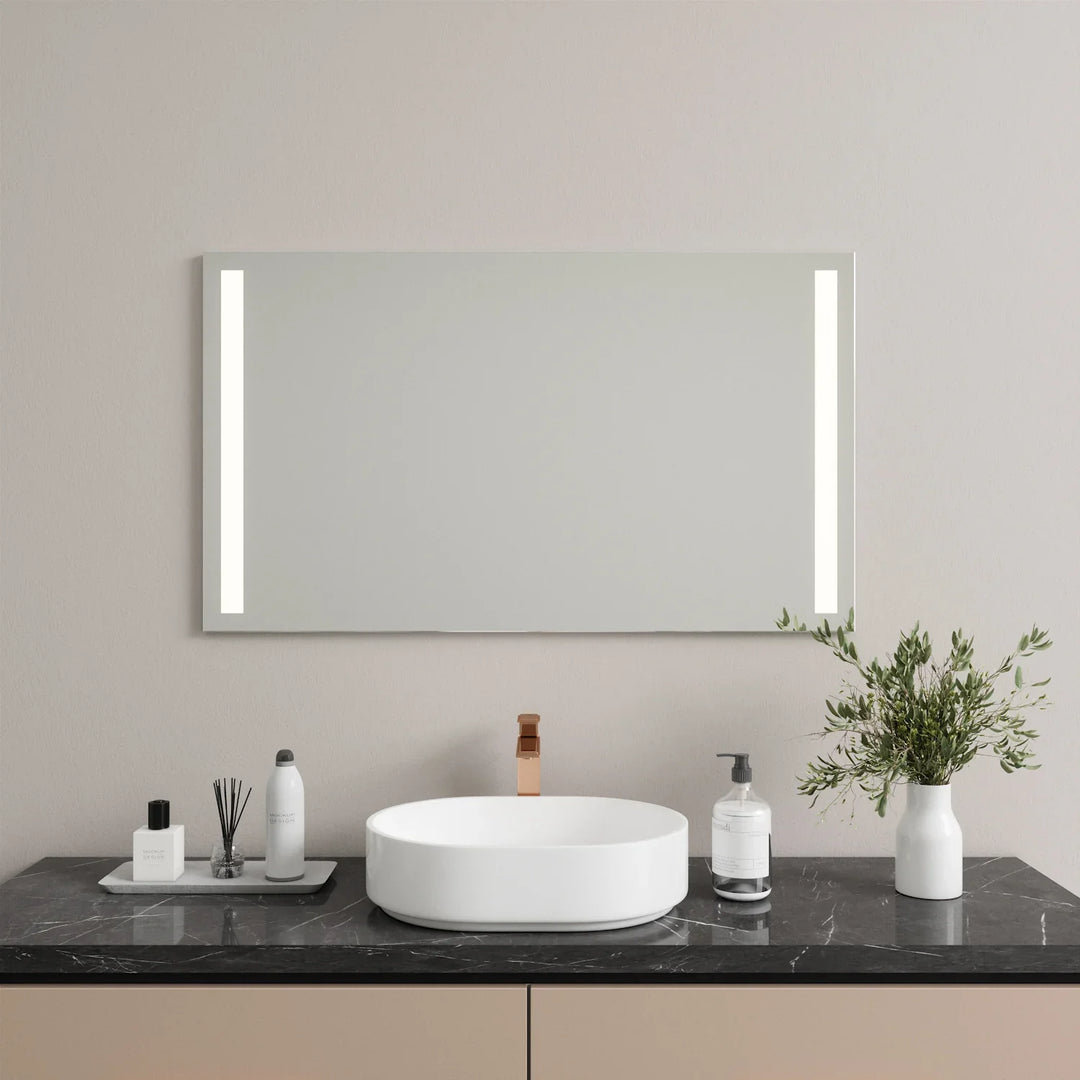 Frameless LED mirror with vertical side lights mounted above white vanity