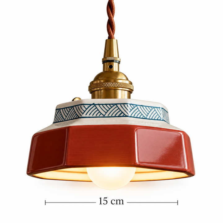 Vintage red enamel pendant light with brass fittings, geometric patterned rim, and twisted fabric cord, 15 cm diameter
