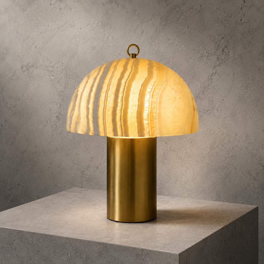 Modern mushroom table lamp with a glowing marble-effect glass dome and brass cylindrical base