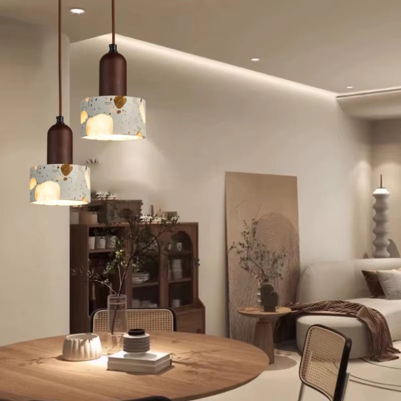 Close-up of a cream terrazzo pendant light shade with multicolored stone chips and a dark brown metal fitting