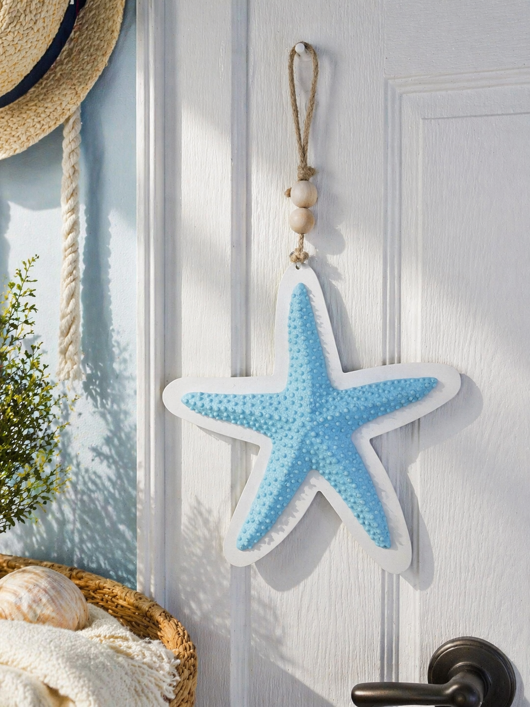 Blue coastal starfish wall hanging with rope and wooden bead decoration for beach-style interiors