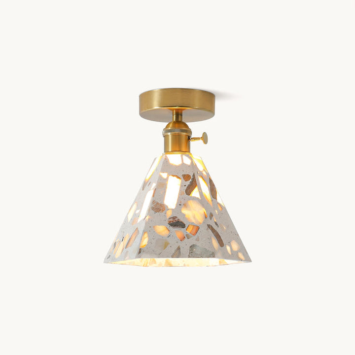 Brass pendant light with a cone-shaped terrazzo-style shade and warm illuminated interior