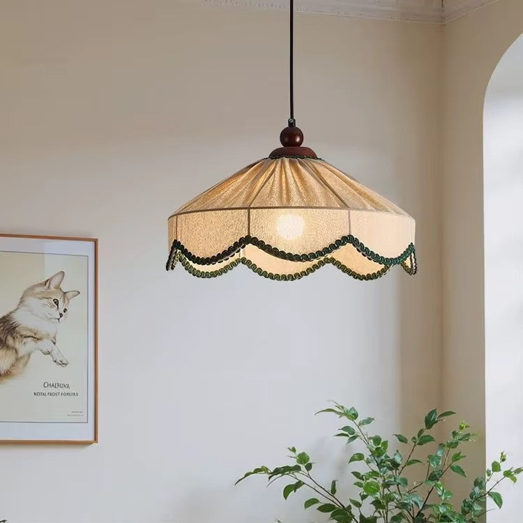 Vintage cream fabric pendant light with pleated shade and dark beaded trim hanging in a classic living room