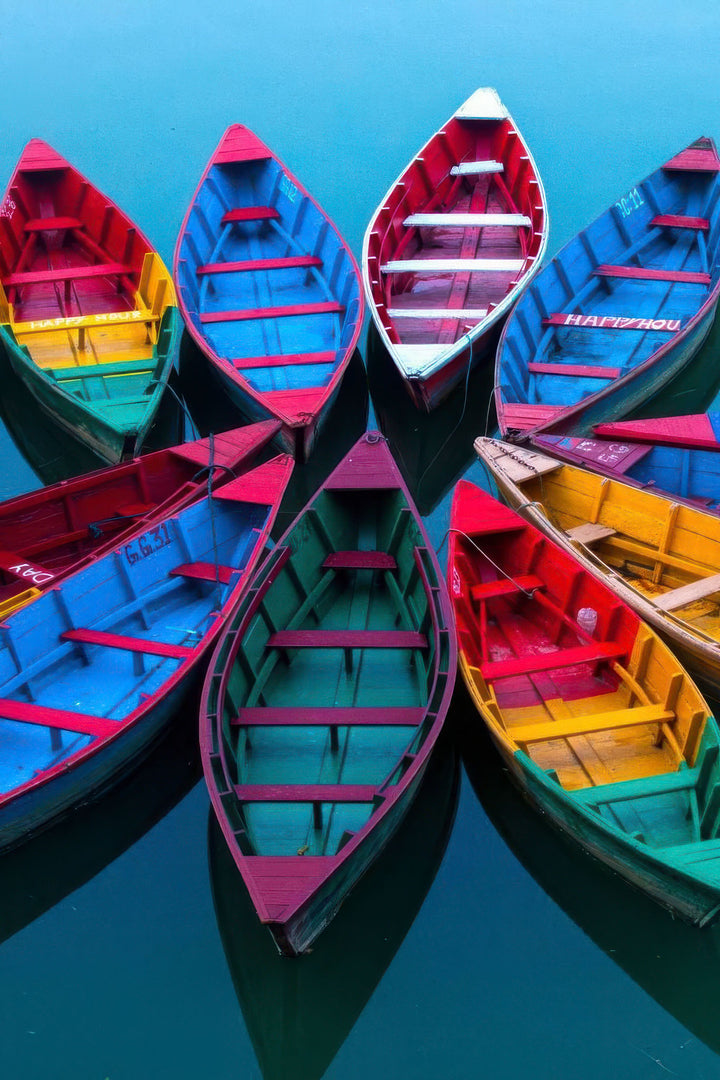 Colorful boats floating on calm blue water canvas wall art
