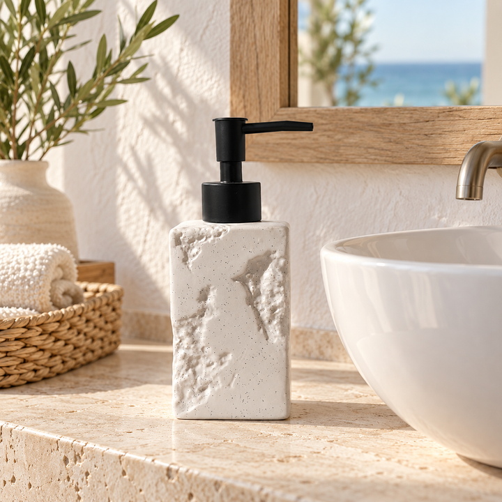 Textured white soap dispenser with black pump beside a bathroom basin