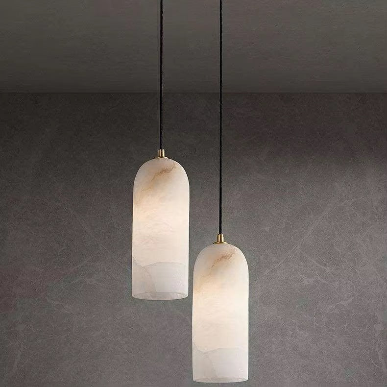 Two cream stone-effect pendant lights hanging at different heights from dark cords