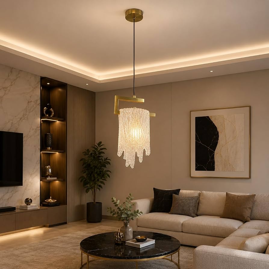 Gold-tone hanging pendant light with a cascading clear glass shade, illuminated in a modern living room.
