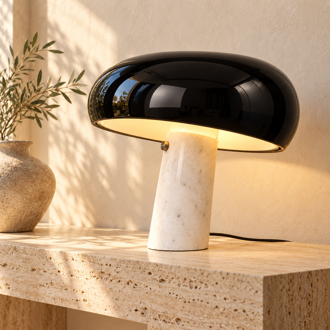 Glossy black dome table lamp with a natural stone base on a textured console table