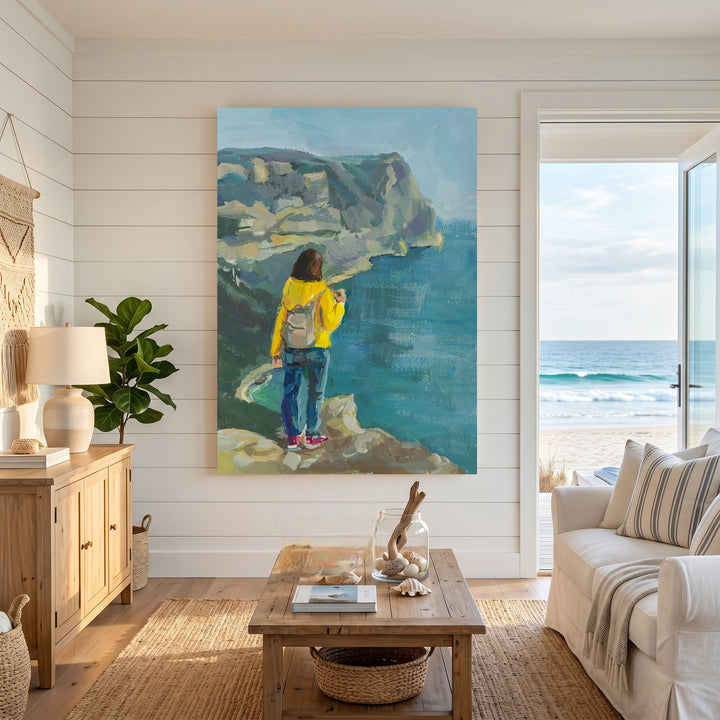 Wadi Home Coastal Cliffside Vista painting with a woman in yellow jacket overlooking the ocean.