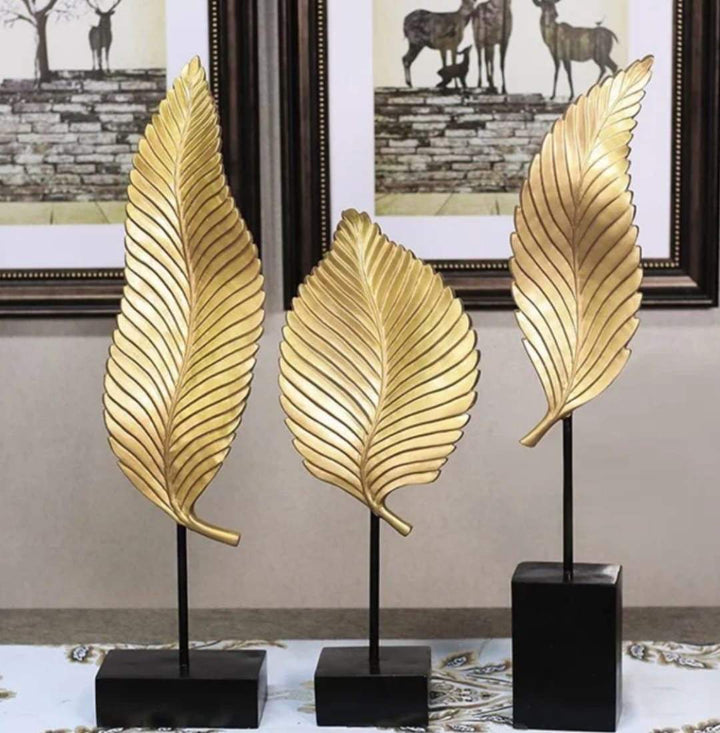 Gold leaf decorative sculpture set with textured metallic leaves on sleek bases