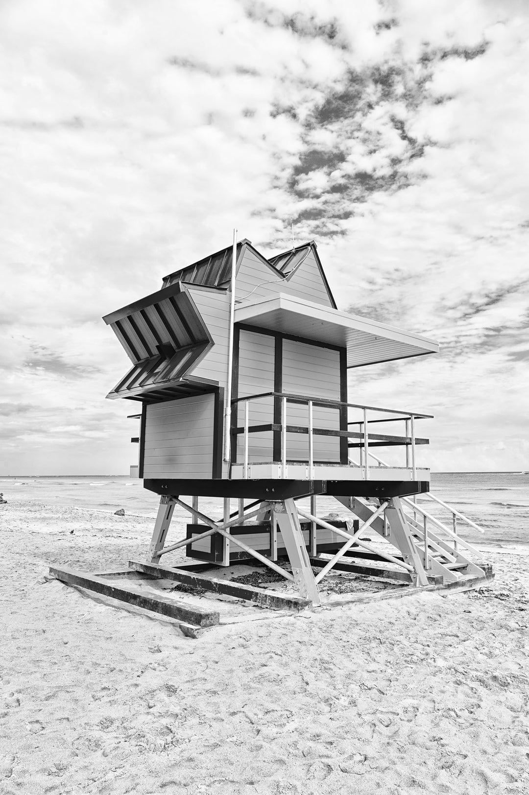 Wadi Home black and white print of a lifeguard tower on a sandy beach under a cloudy sky.