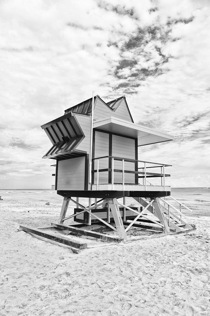 Wadi Home black and white print of a lifeguard tower on a sandy beach under a cloudy sky.