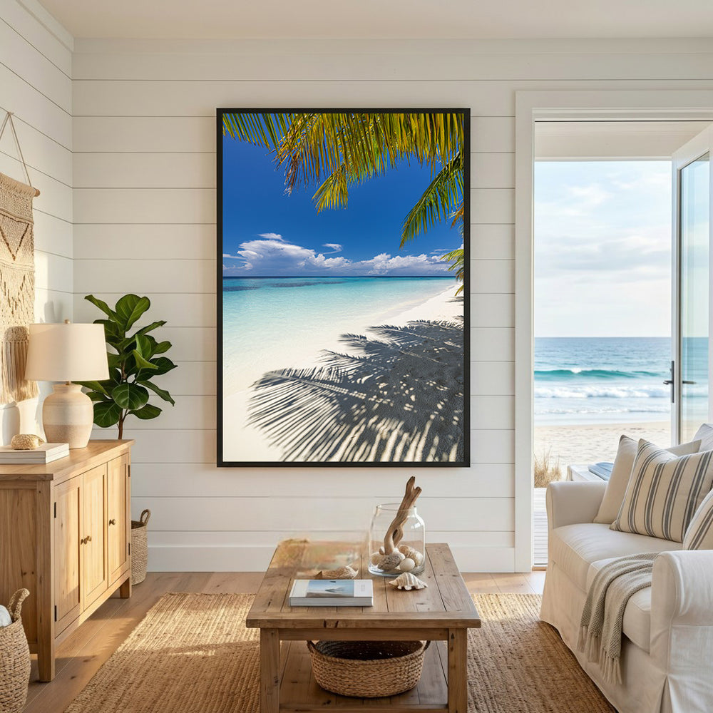 Wadi Home framed wall art of a tropical beach with palm tree shadows on white sand and turquoise water under a blue sky.