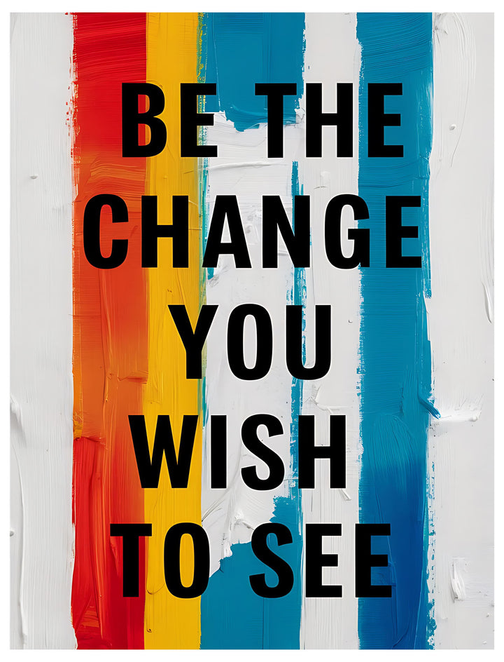 Wadi Home motivational wall art with black text "Be The Change You Wish To See" on a background of vertical red, orange, yellow, blue, and white brushstrokes.