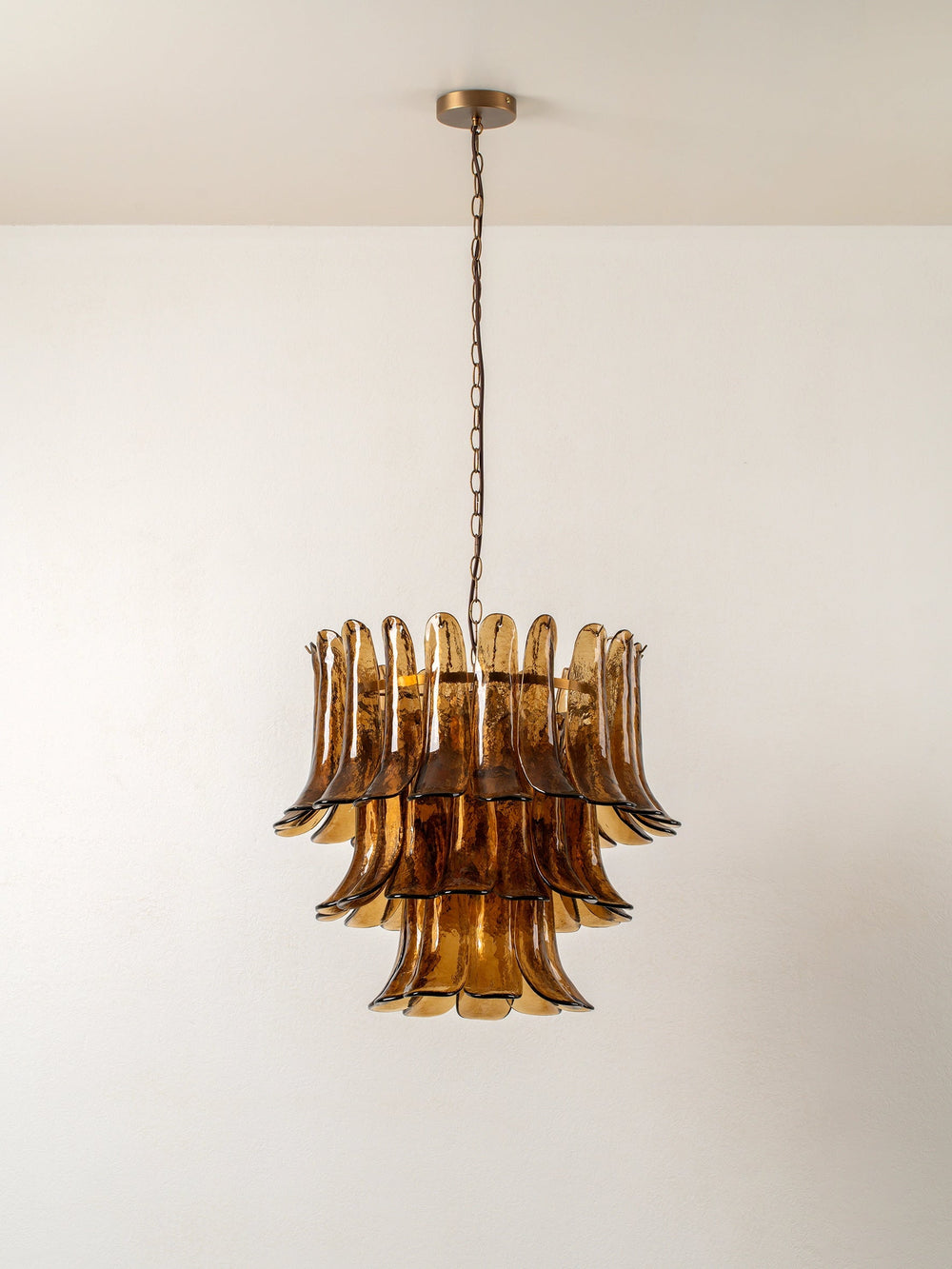 Sculptural amber glass petal chandelier with gold-tone detailing and hanging chain