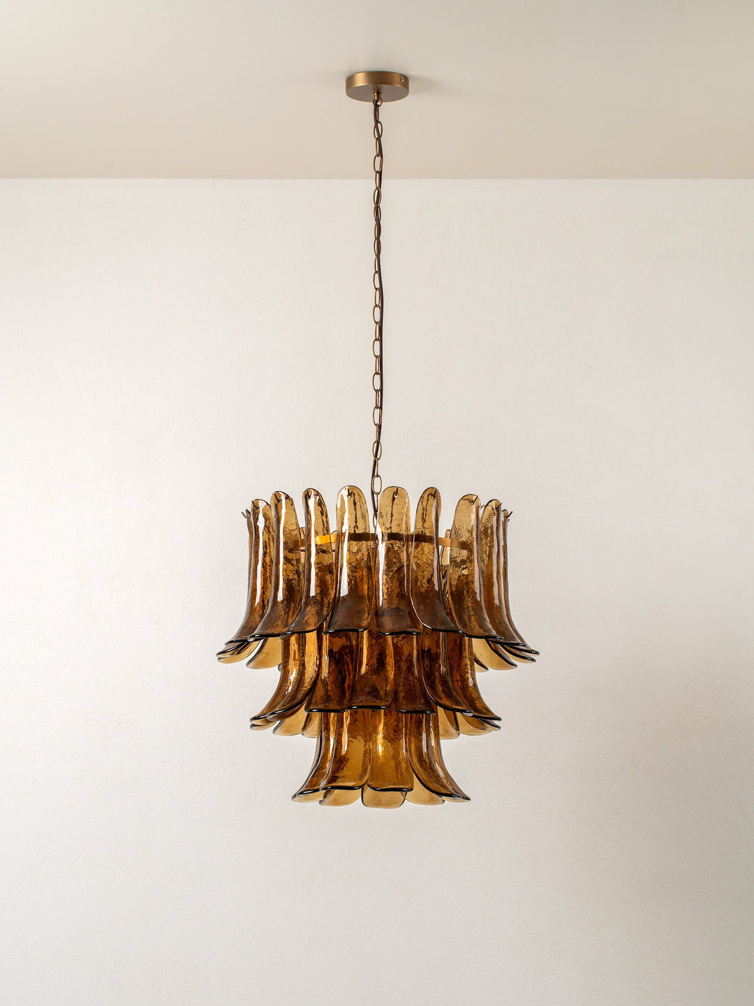 Sculptural amber glass petal chandelier with gold-tone detailing and hanging chain
