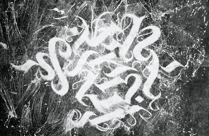 Wadi Home abstract calligraphy wall art with white brushstrokes on textured black background. Modern, dynamic art for living rooms.