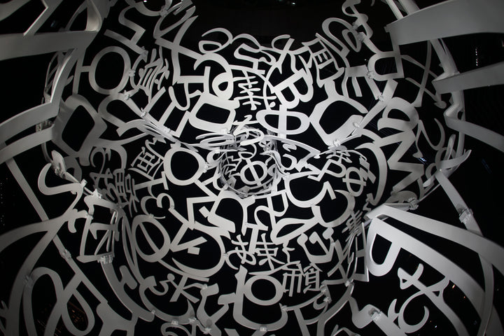 Wadi Home abstract monochrome typography face wall art print with intricate letters and symbols forming a human face.