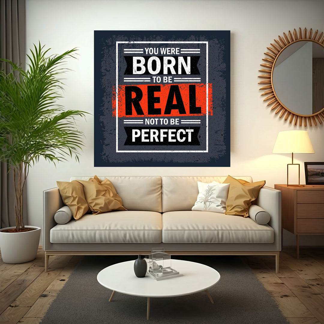 Wadi Home motivational wall art with bold white text on dark grey background: "You Were Born To Be Real Not To Be Perfect".