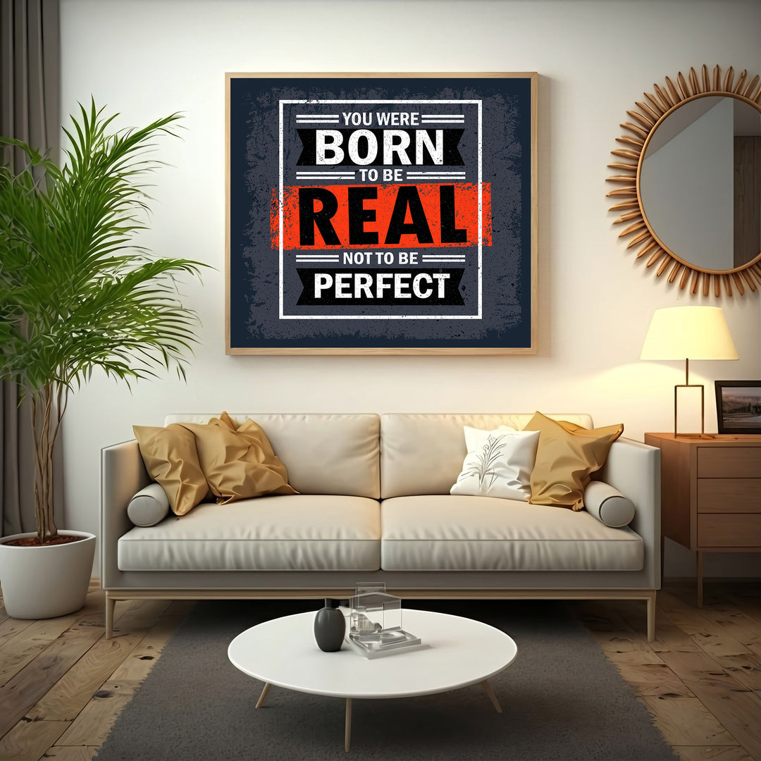 Wadi Home motivational wall art with bold typography: "You Were Born To Be Real Not To Be Perfect" in black, white, and orange.