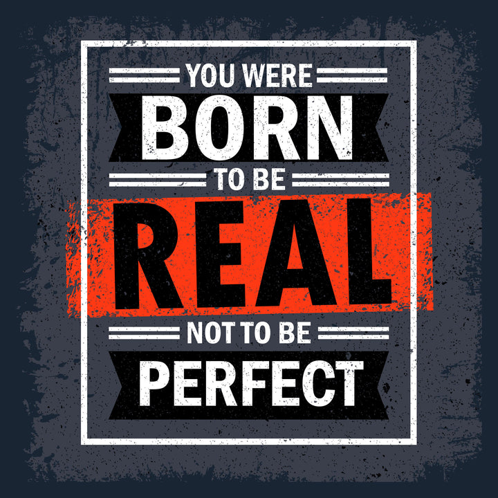 Wadi Home motivational wall art with bold white text on dark grey background: "You Were Born To Be Real Not To Be Perfect".