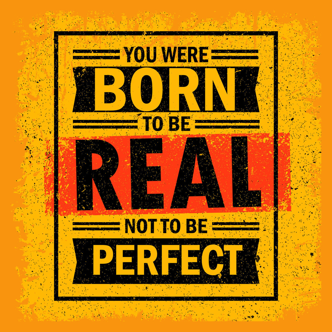 Wadi Home motivational wall art with bold yellow, black, and red typography reading 'You Were Born To Be Real Not To Be Perfect'.