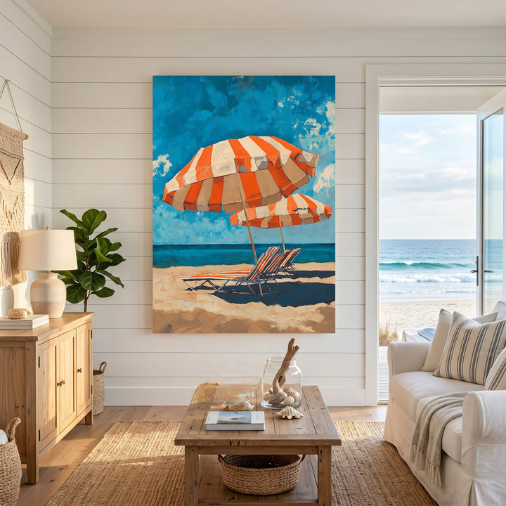 Wadi Home orange and white striped beach umbrellas and lounge chairs on sandy shore with blue sky and ocean.