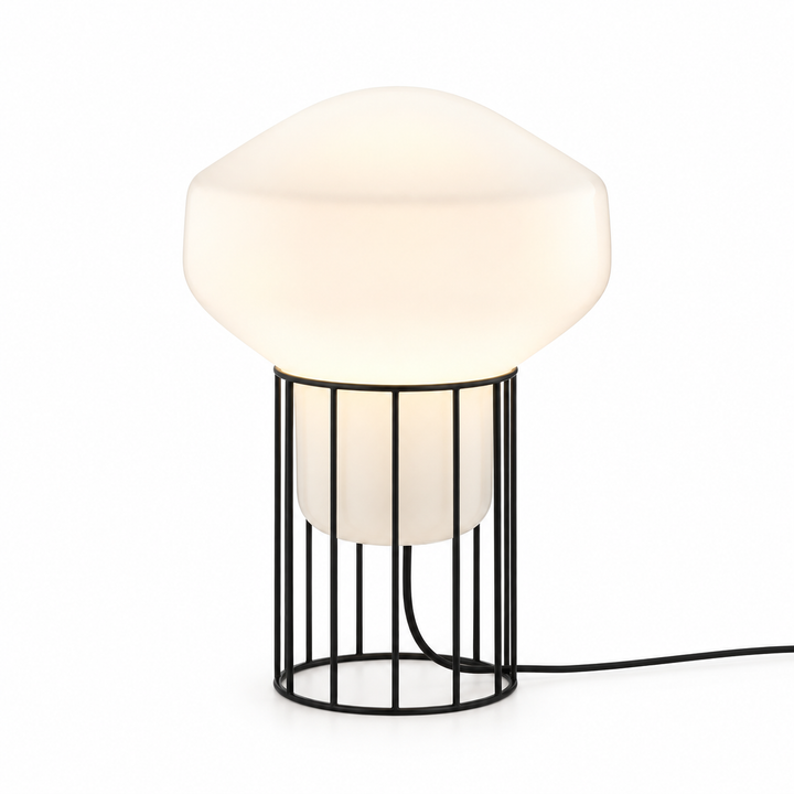 Modern white globe table lamp with a black metal cage base and visible power cord