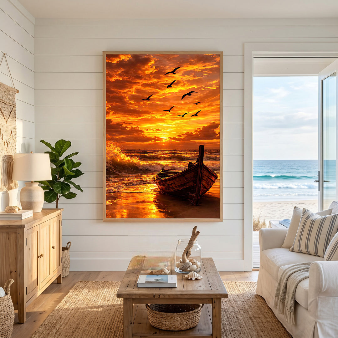 Wadi Home Serene Sunset Boat Wall Art: A wooden boat rests on a sandy beach with waves crashing and birds flying in a vibrant orange and yellow sunset sky.