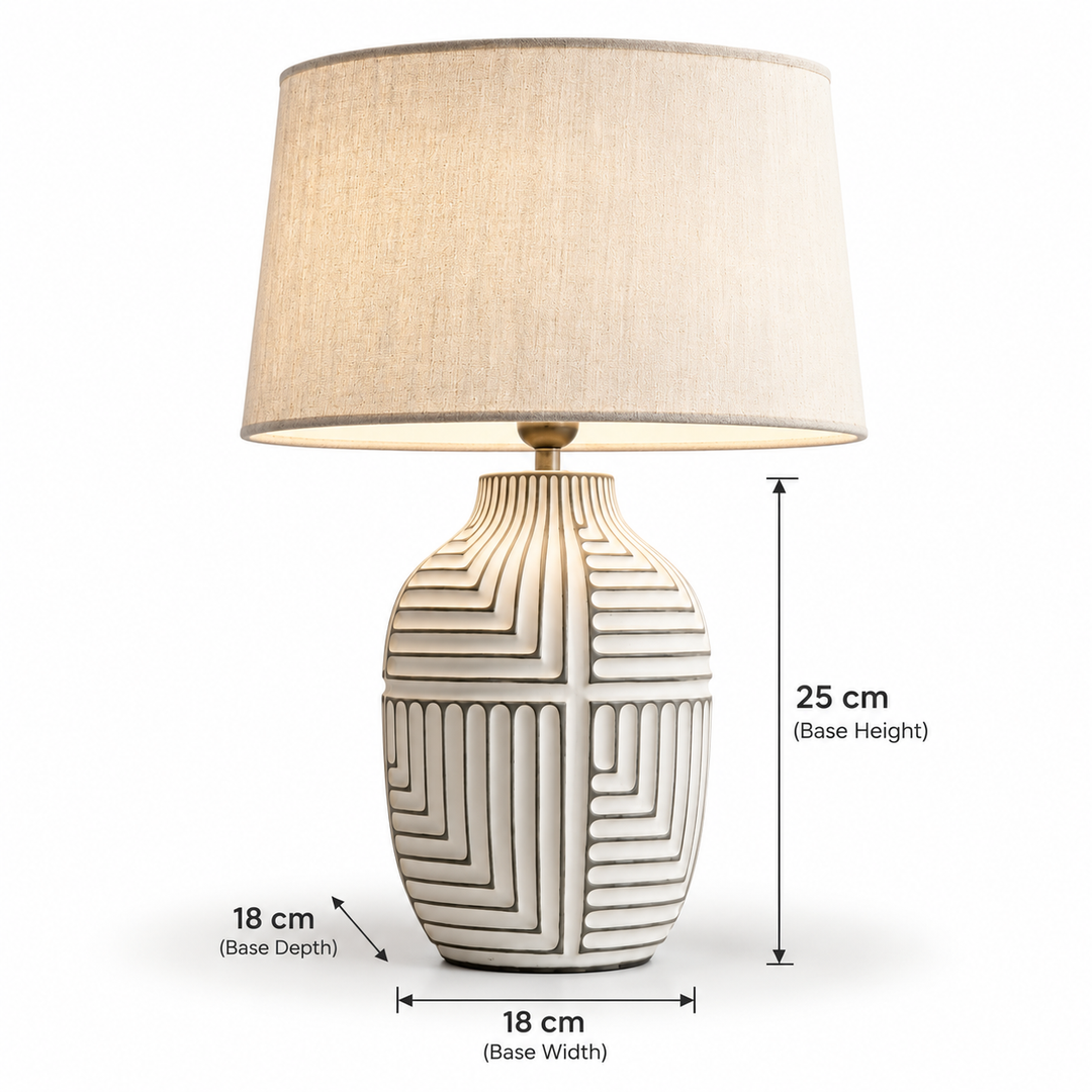 Cream geometric ceramic table lamp with a textured sculptural base and fabric drum shade