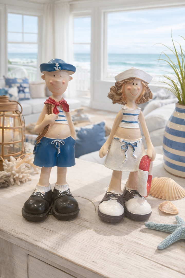 Beach couple figurines in nautical outfits on a seaside-themed display