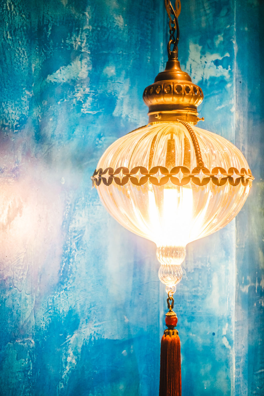 Wadi Home decorative wall art print featuring a glowing lantern against a textured blue background above a sofa.