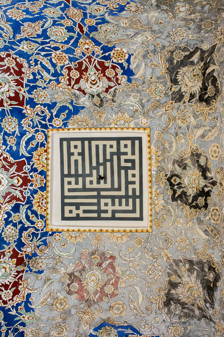 Wadi Home traditional Arabic Kufic calligraphy wall art print with ornate blue and gold floral patterns in a living room