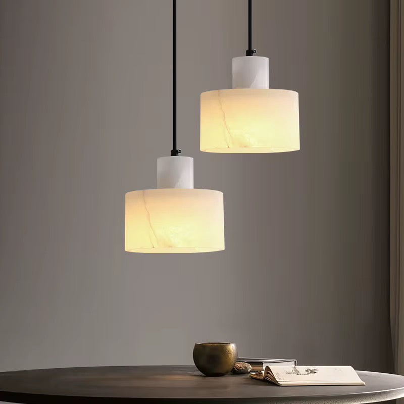Pair of modern ivory pendant lights with textured stone-effect shades and black suspension cords