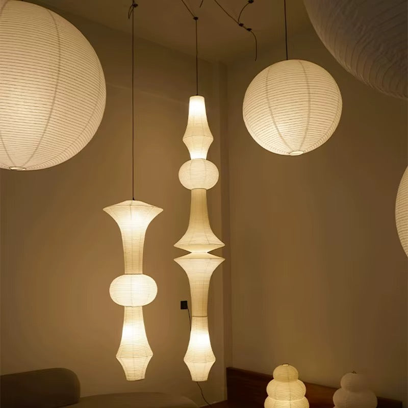 Sculptural warm white paper pendant light with a tiered lantern shade suspended in a modern interior