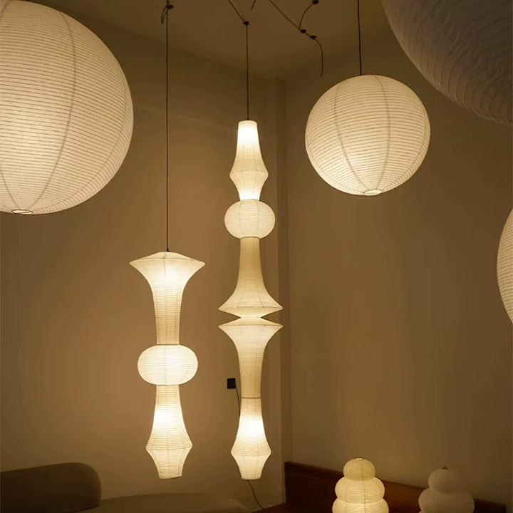 Sculptural warm white paper pendant light with a tiered lantern shade suspended in a modern interior
