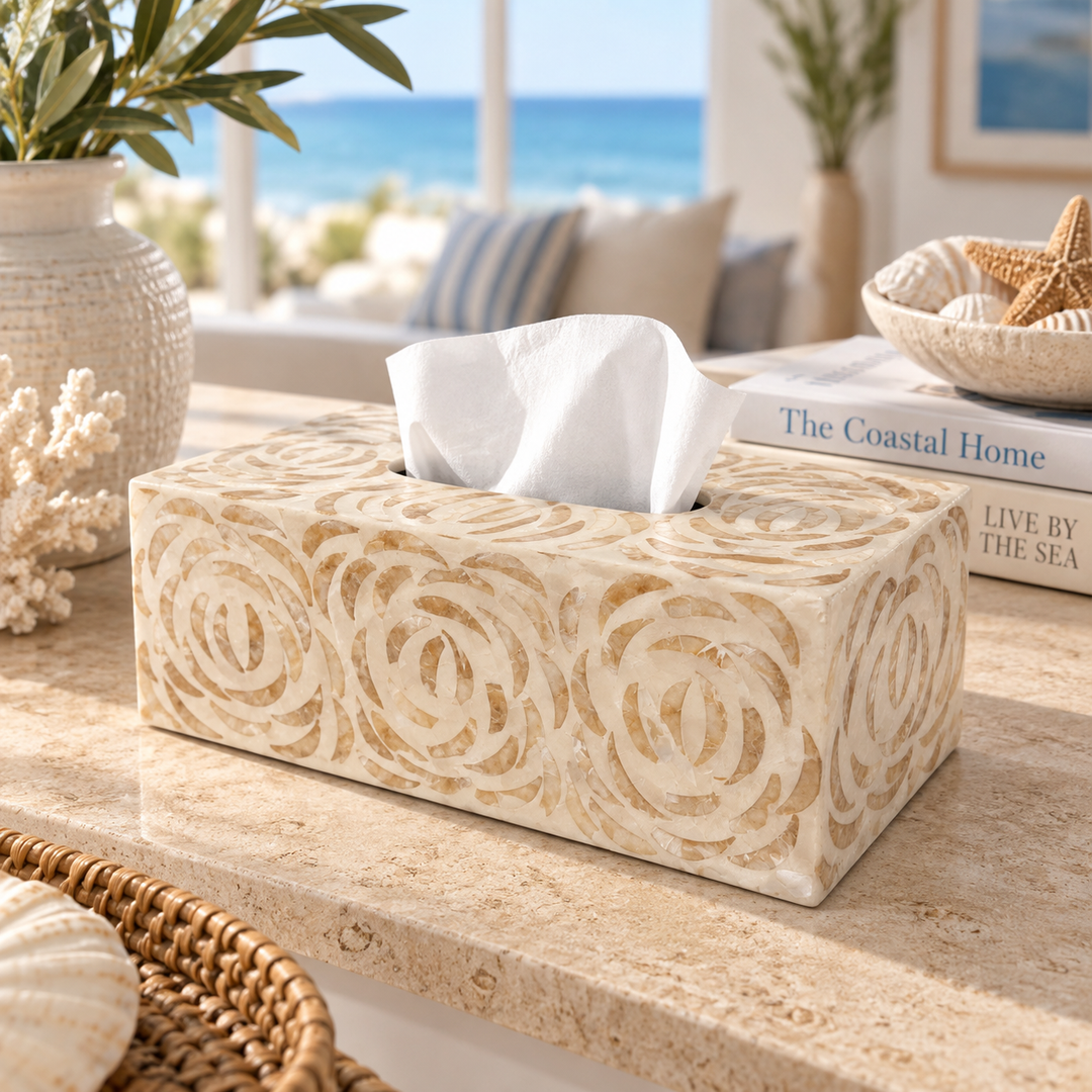 Ivory carved swirl tissue box cover with white tissue, displayed on a coastal-style console table