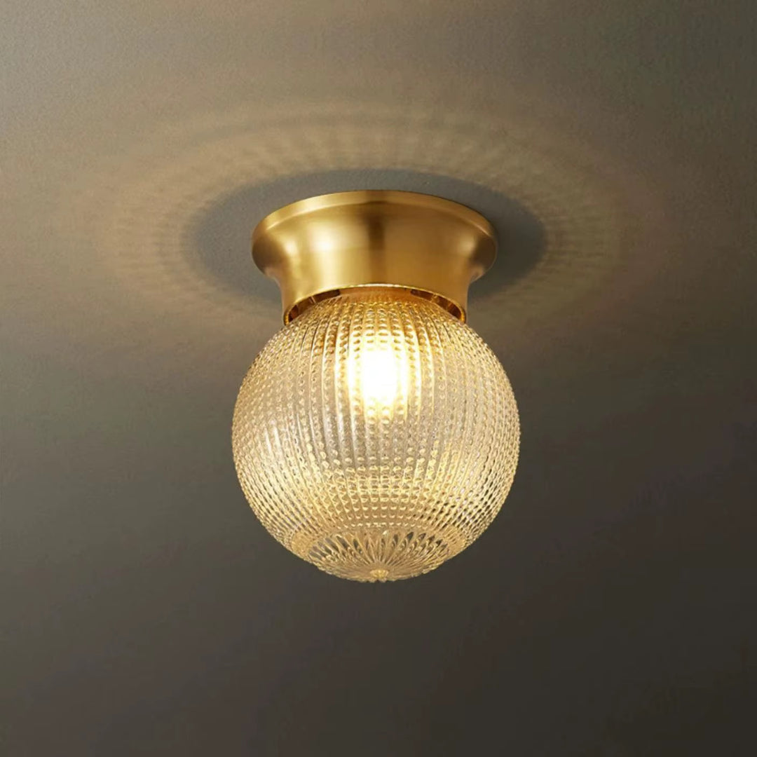 Vintage brass flush-mount ceiling light with a textured glass globe