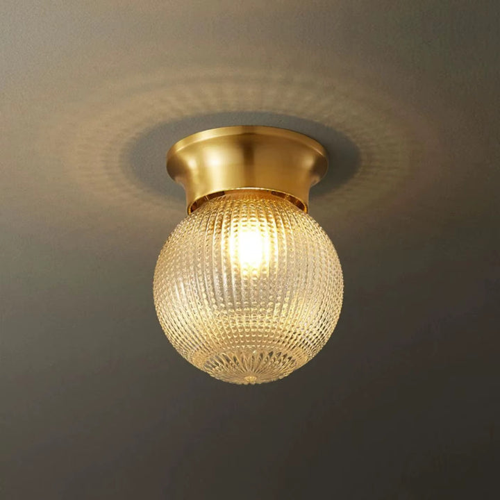 Vintage brass flush-mount ceiling light with a textured glass globe