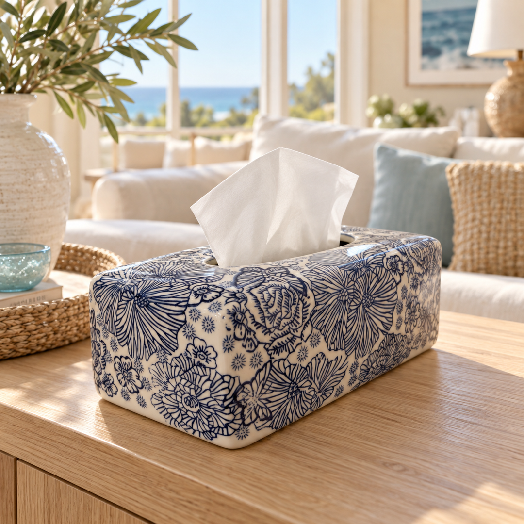 Blue and white floral tissue box cover on a wooden coffee table in a bright coastal-style living room