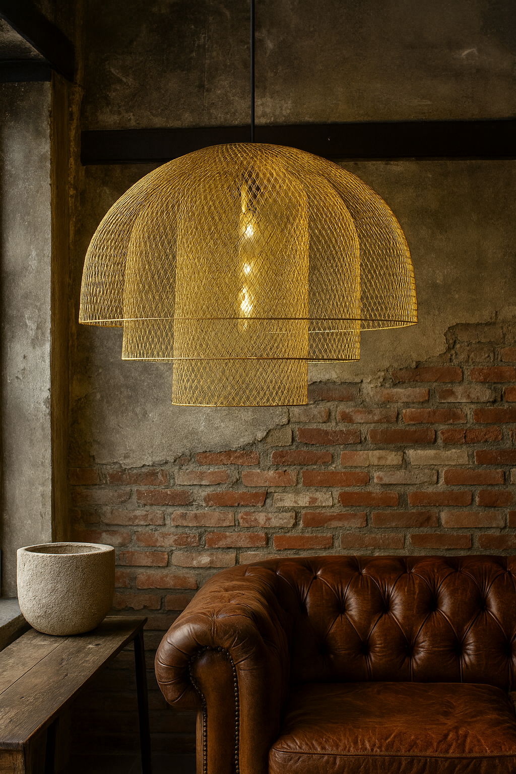 Golden mesh dome pendant light with layered design hanging above a leather sofa