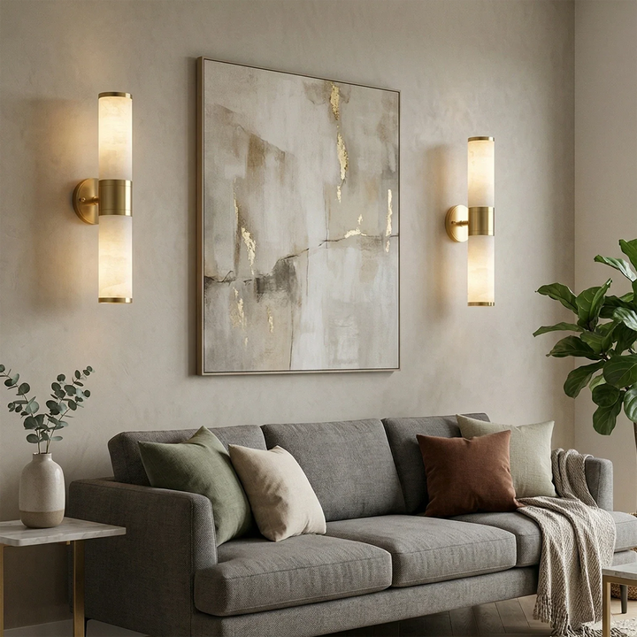 Modern brass wall light with vertical opal glass shades beside artwork in a contemporary living room