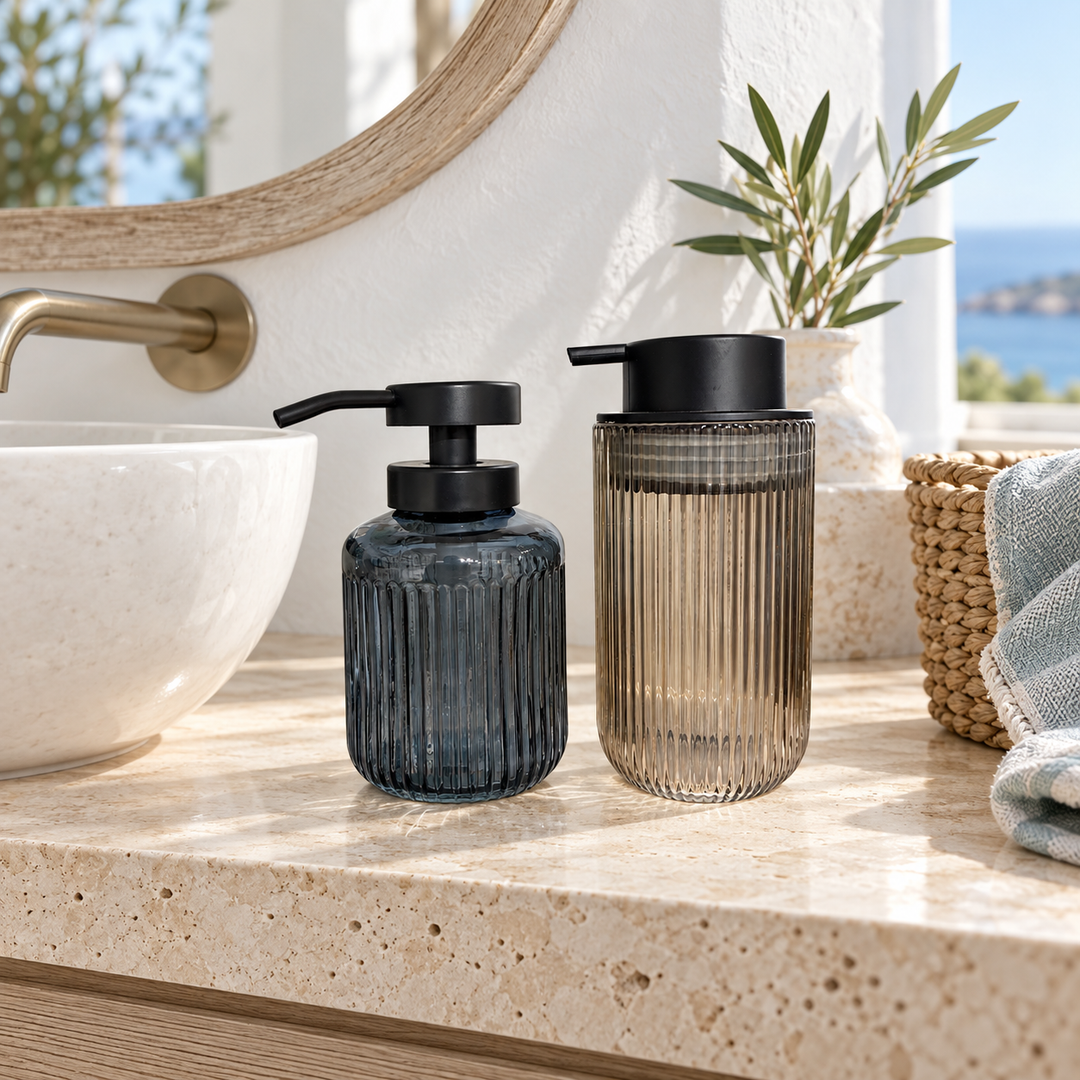 Ribbed glass soap dispenser set with black pumps on a modern bathroom countertop