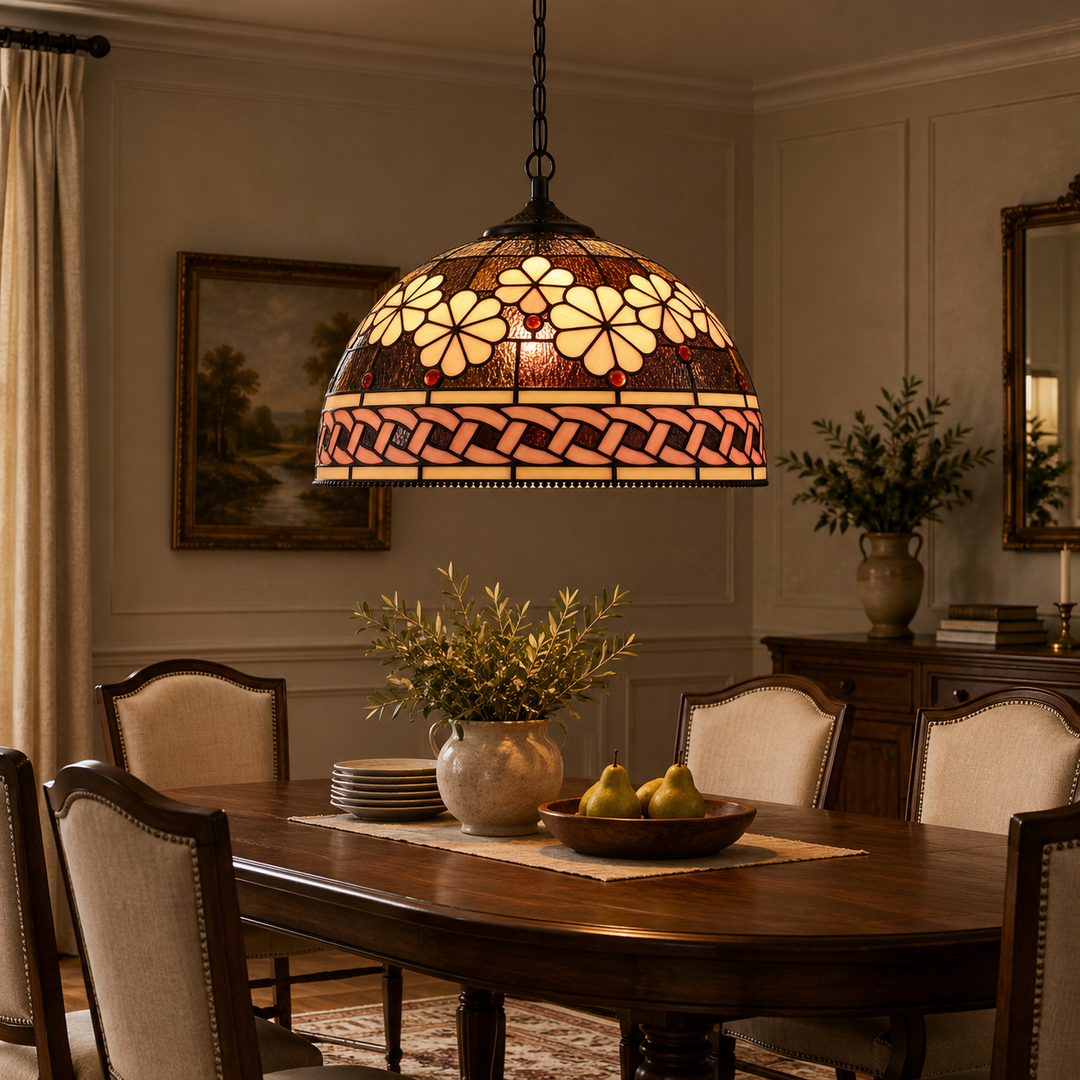 Vintage floral stained glass pendant light with a warm amber glow and decorative dome-shaped shade hanging above a dining table.