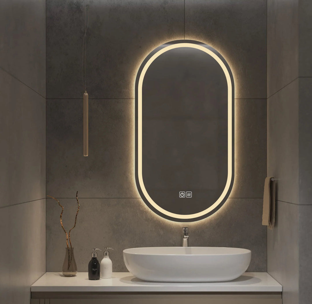 Bathroom vanity with a illuminated oval mirror and sink.