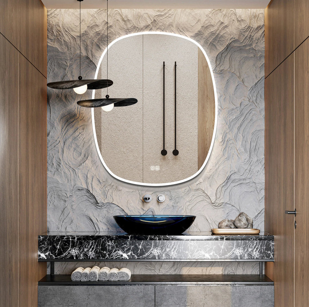 Modern bathroom vanity with marble countertop, black sink, and oval mirror with lights.