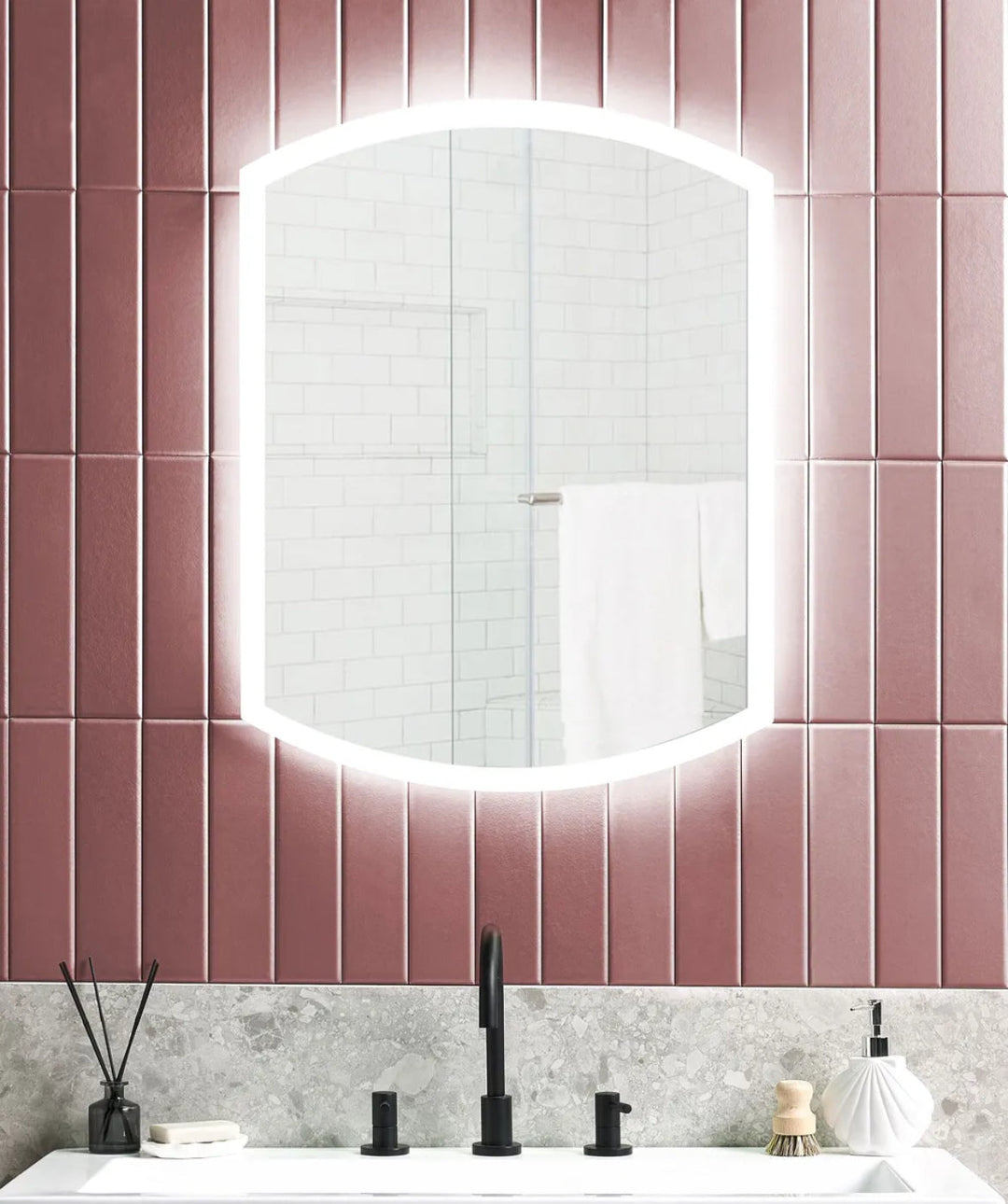 Bathroom with a round mirror on a pink tiled wall