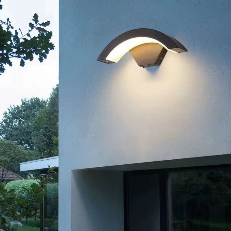 Modern Arc Outdoor Wall Light with curved design and soft diffused glow on exterior wall