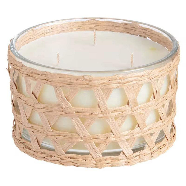 Woven glass scented candle in clear jar with straw wrap and multiple wicks for cozy ambiance